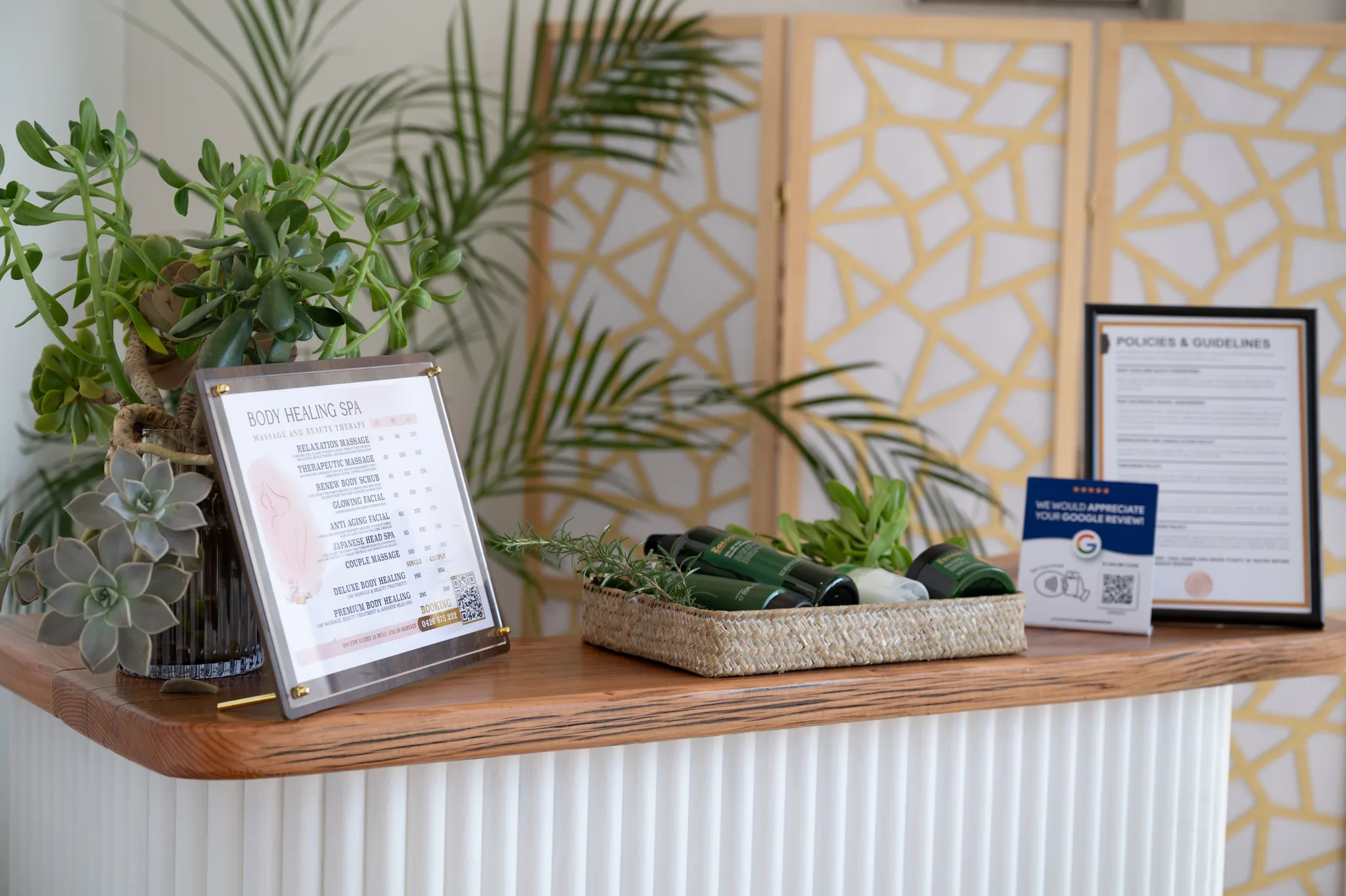 Reception detail — jade plants, seagrass tray and gold folding screen