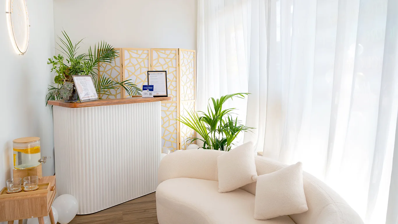 Reception — white fluted desk, gold geometric screen and bouclé seating